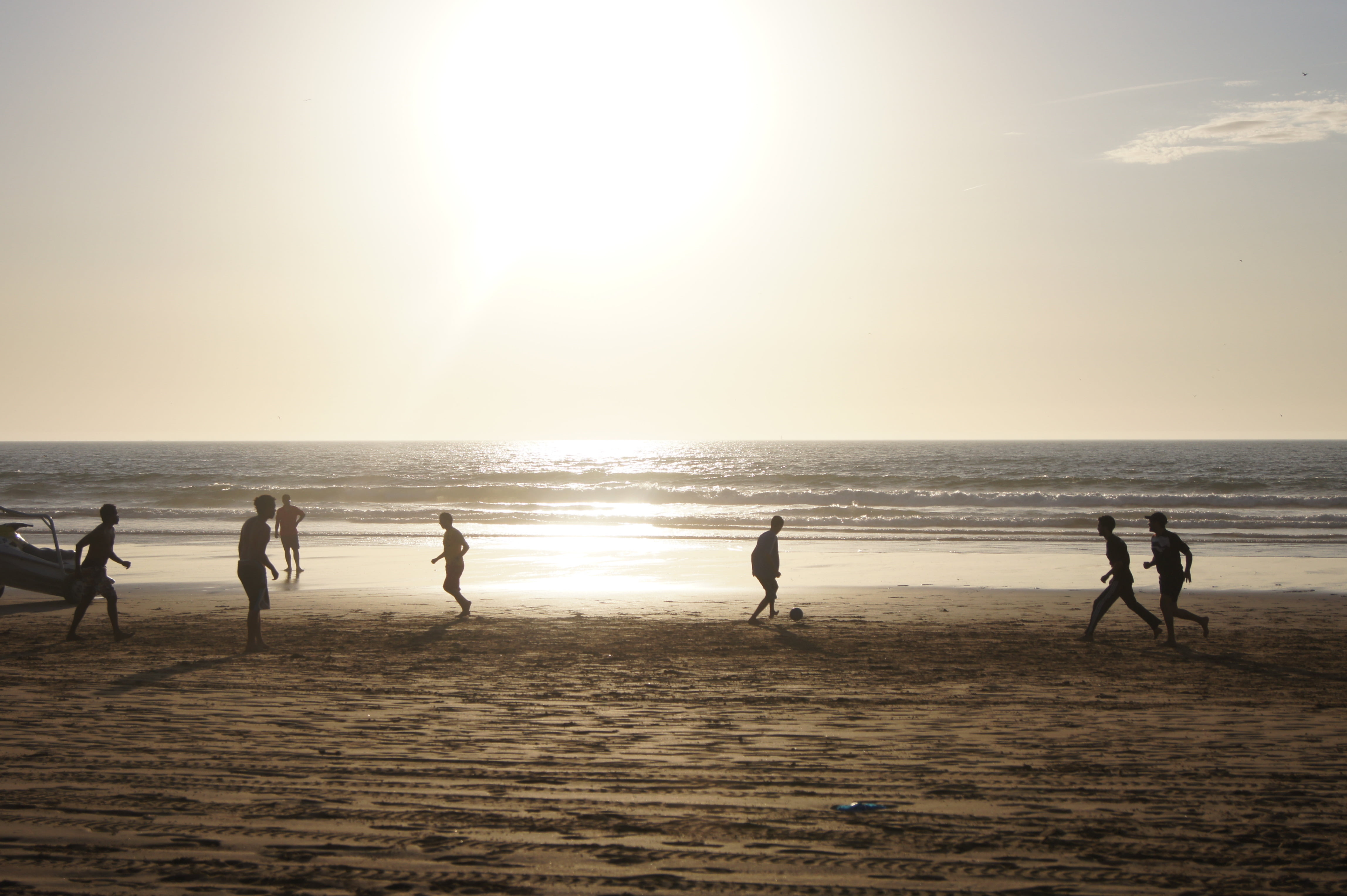 silhouette of seven person near the sea during daytime