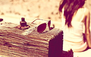 black aviator sunglasses on brown wooden surface