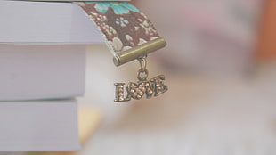 gold-colored Love pendant accessories on white cardboard box
