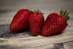 tilt shift lens photography of three strawberries HD wallpaper