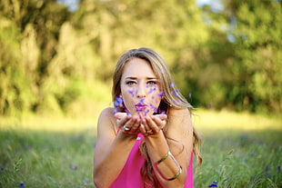 fish eye photography of woman in pink blowing purple flowers