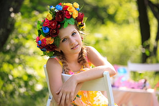 girl wearing floral head dress sitting in the garden