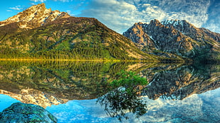 reflective photography of mountain and river
