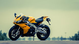 Shallow focus photo of yellow and gray sports bike