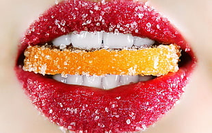 lips biting orange sugar coated food HD wallpaper