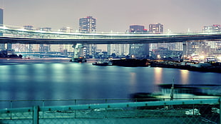 photo of bridge near in city under gray sky HD wallpaper
