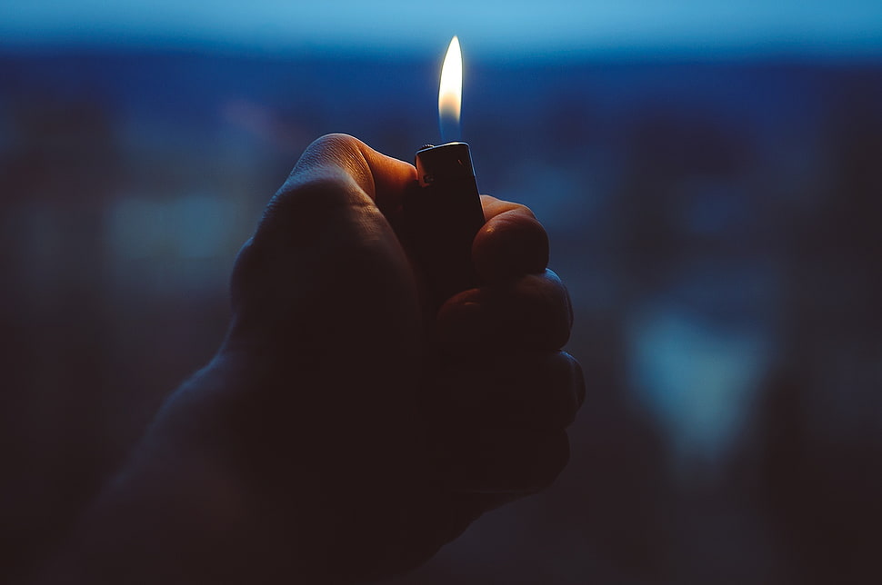 person holding disposable lighter HD wallpaper