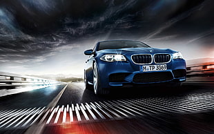 blue BMW car passing through road under clouds