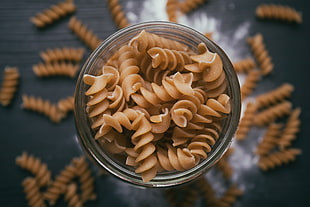 tilt-shift photography of brown pasta spiral on jar