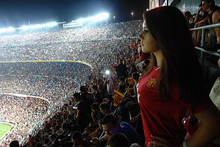 woman in red jersey shirt standing on soccer field