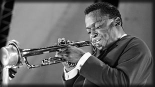 grayscale photo of man playing trombone