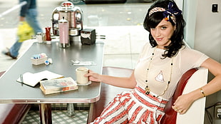 Katy Perry sitting on a bench