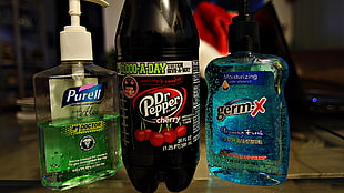 Dr Pepper bottle near two Purell and Germ X push bottles