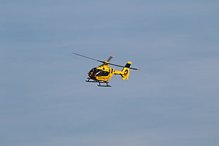 yellow and black helicopter top of sky