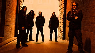 five man wearing black shirts standing on the ground