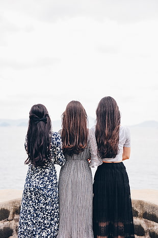 three girls standing on brown bricks
