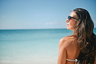 woman look up wearing bikini near shore