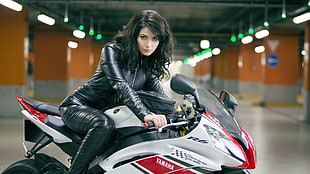 woman riding on black, white, and red Yamaha sports bike
