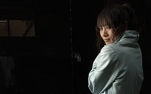 woman wearing gray jacket near metal door