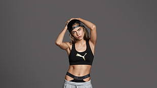 photo of woman in black puma sports bra and gray track pants