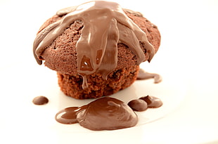 baked chocolate muffin with chocolate syrup toppings closeup photo