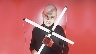 man holding LED lighted cross