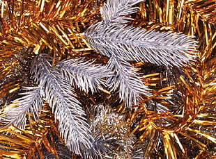 close up photo of gold tinsel on white Cristmas tree