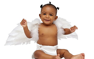 toddler wearing white wings and fabric diaper sitting