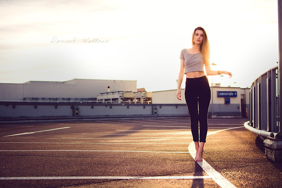woman wearing gray top and black leggings standing on concrete ground HD wallpaper