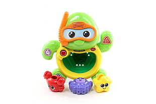 green, yellow, and red turtle toy with white background