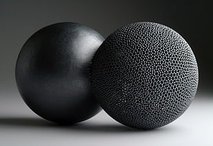 close up photo of two round black metal balls
