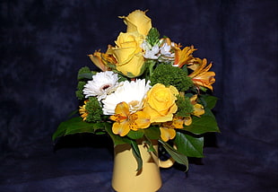 white, orange and yellow flower bouquet on vase with blue background