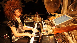 woman wearing brown bolero plays piano