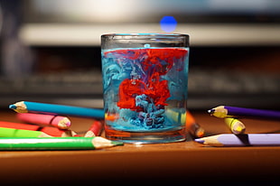 clear shot glass, table, glass, water, pencils
