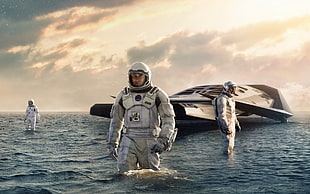 man in white astronaut suit walking on body of water