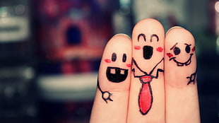 person's fingers with smiley drawings