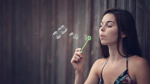 photo of woman holding a bubble maker