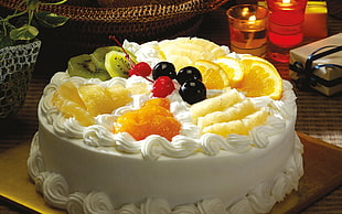 vanilla frosted cake with assorted fruit toppings
