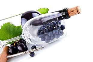 grapes in wine glass and wine bottle
