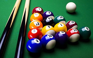 two beige-and-black cue sticks and pool ball set, billiard balls, pool table