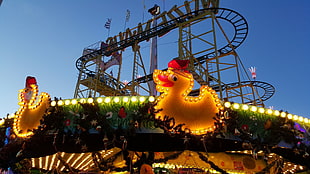 two duckling with light fixture overlooking roller coaster