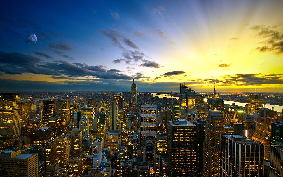 aerial view of city with high-rise buildings under blue and yellow skies HD wallpaper