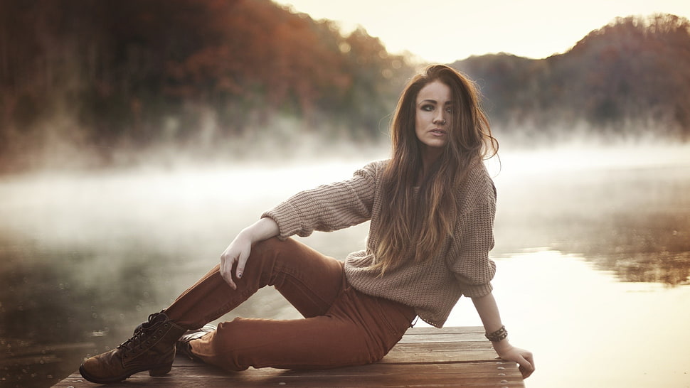 woman sitting on dock bridge near body of water HD wallpaper