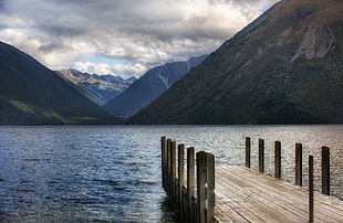 landscape photo of brown wooden dock and mountain near lake