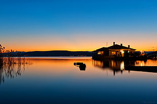 silhouette of house beside the body of water HD wallpaper