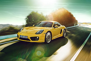 yellow Porsche 911 on concrete road