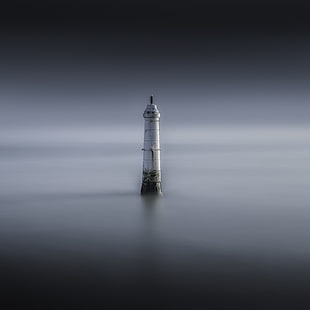 white concrete tower surrounded by water