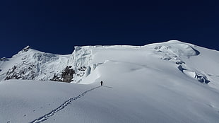 person walking on mountain of snow during daytime
