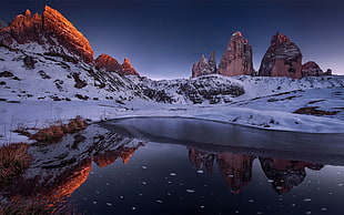 body of water near brown rock formations on snow covered mountain, landscape, rock, reflection, snow