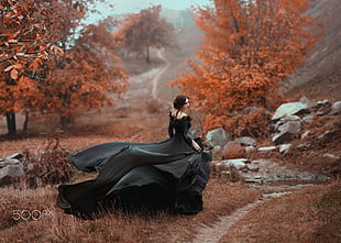 woman wearing black off-shoulder maxi dress standing between forest trees HD wallpaper